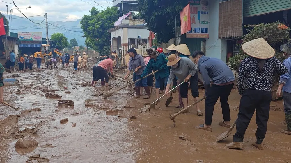 Người dân ở xã Sông Mã (tỉnh Sơn La) tập trung dọn dẹp sau khi lũ rút, ngày 2-8