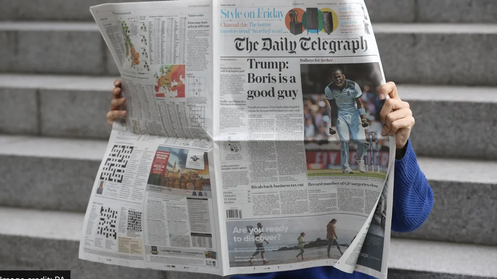 Độc giả xem báo của The Telegraph. Ảnh: JONATHAN BRADY/ PA WIRE 