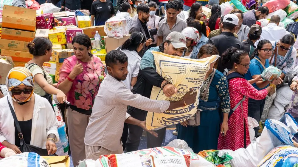 Tình nguyện viên ở Kathmandu hỗ trợ nhu yếu phẩm cho người dân khu vực bị lũ lụt. Ảnh: XINHUA