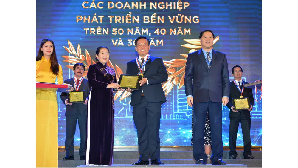 Phó Bí thư Thành ủy TPHCM Võ Thị Dung chúc mừng các doanh nghiệp phát triển bền vững trên 50 năm. Ảnh: Việt Dũng