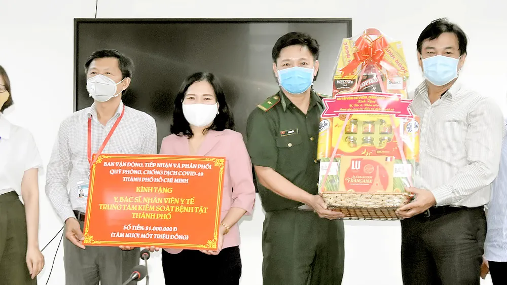 Đồng chí Nguyễn Thị Thu Hoài (thứ 3 từ trái sang) tặng quà Ban giám đốc Trung tâm Kiểm soát bệnh tật TPHCM
