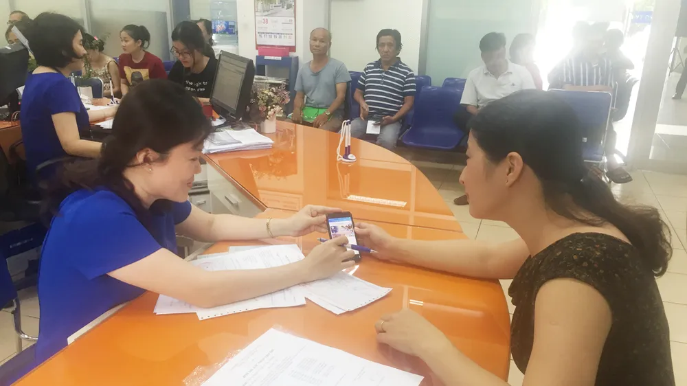 Nhân viên EVNHCMC hướng dẫn khách hàng cài đặt và sử dụng app EVNHCMC CSKH. Ảnh tư liệu