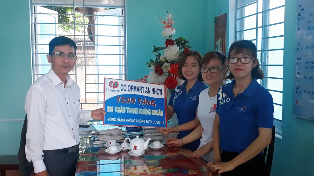 Đại diện Co.opmart Quy Nhơn và Co.opmart An Nhơn tặng khẩu trang cho địa phương