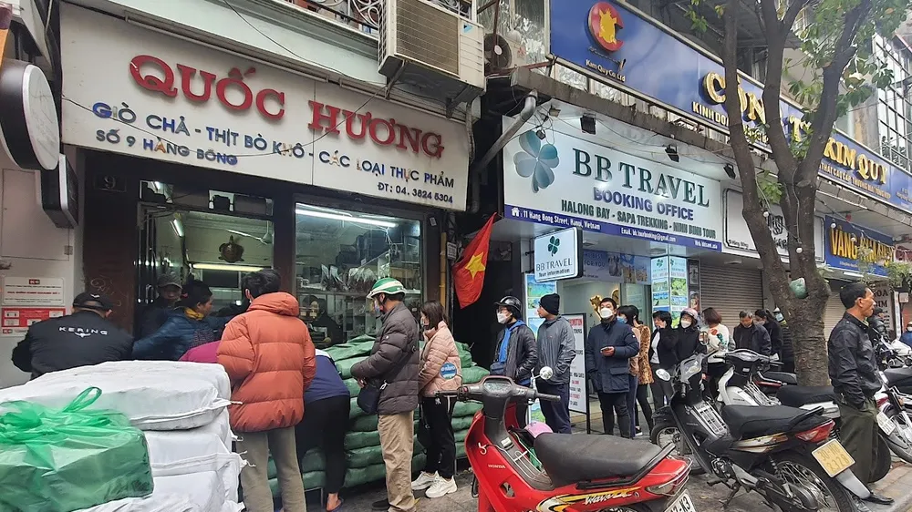 Người dân Hà Nội kiên nhẫn xếp hàng để mua bánh chưng, giò chả tết 