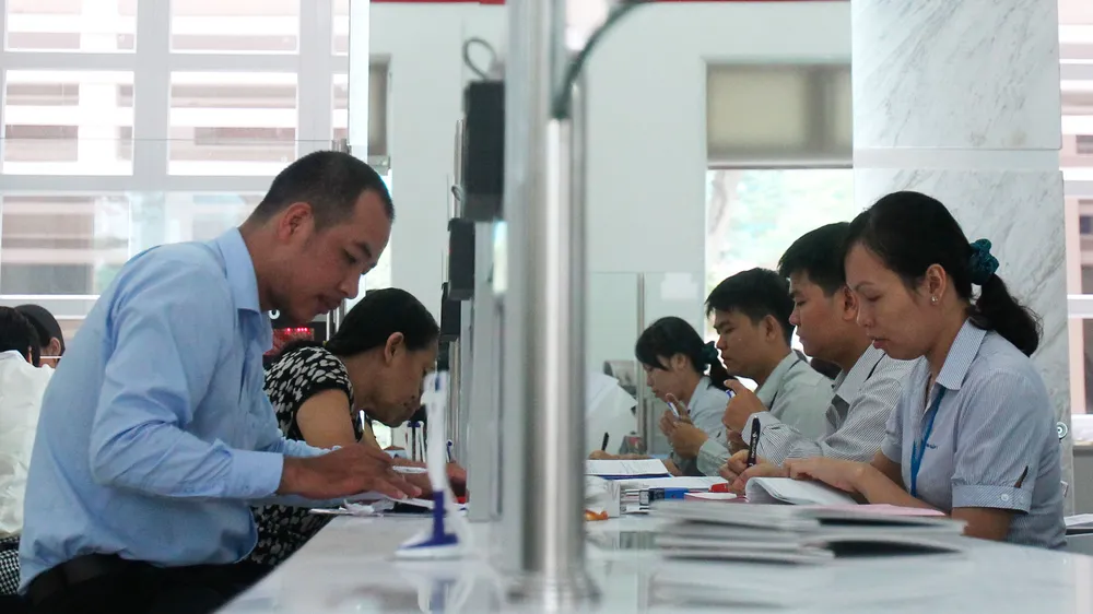 Cán bộ UBND quận 1 (TPHCM, bìa phải) giải quyết hồ sơ cho người dân