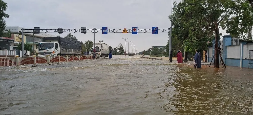 Quốc lộ 1A qua địa bàn thị xã Hương Trà bị ngập sâu khiến người và phương tiện tham gia giao thông gặp khó khăn