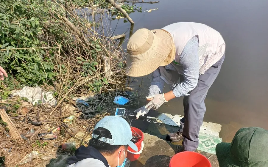 Lấy mẫu nước tại khu vực xảy ra tình trạng cá chết trên sông Ô Giang