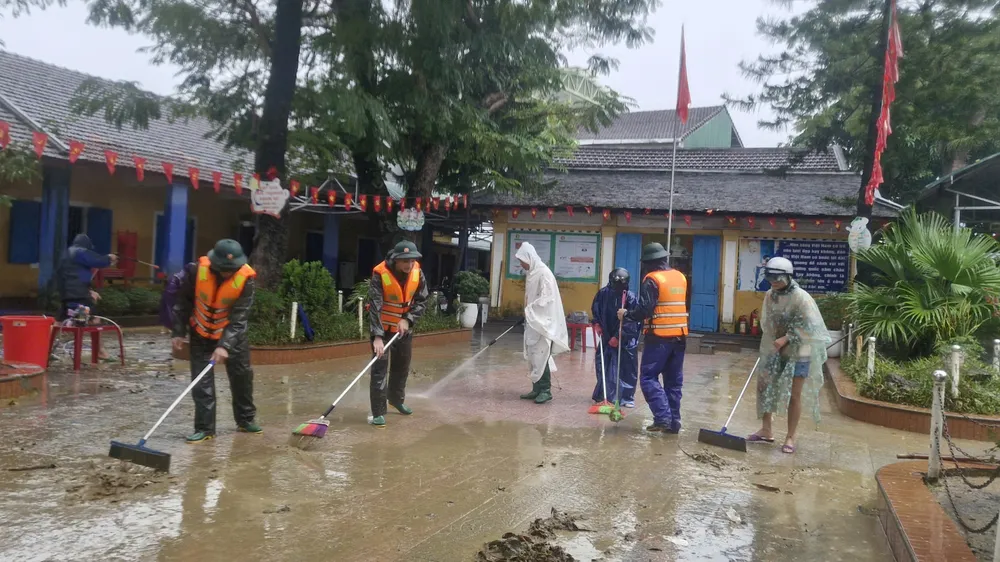 Quân đội giúp thầy trò Trường Tiểu học số 1 An Đông dọn bùn đất sau khi lũ rút 
