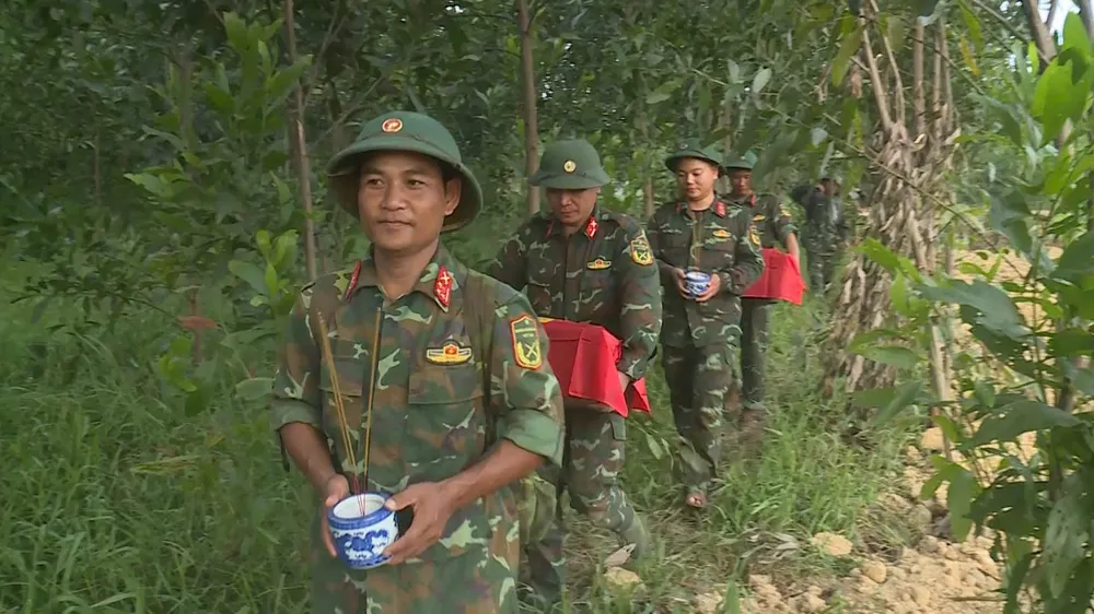 Rước 10 hài cốt liệt sĩ vừa được quy tập về quàn tại Đền thờ Liệt sĩ Trung đoàn 88, Sư đoàn 308 ở khu vực Câu Nhi