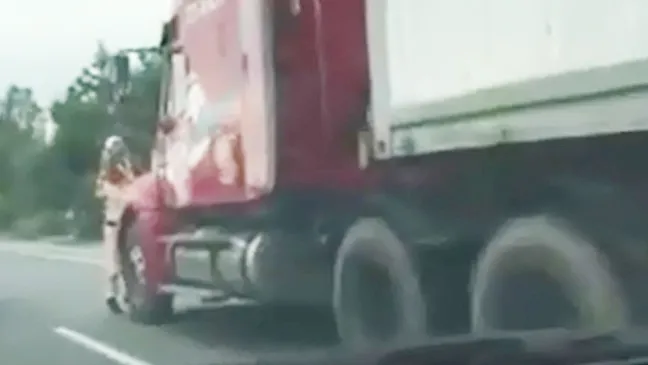 Chiến sĩ CSGT bám trước cần gạt và gương xe container