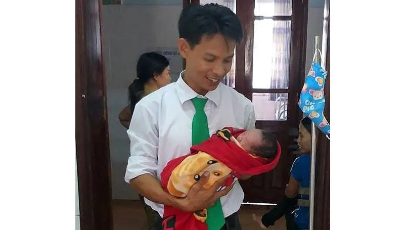 Tài xế Nguyễn Đăng Ngự bên cháu bé mới sinh 