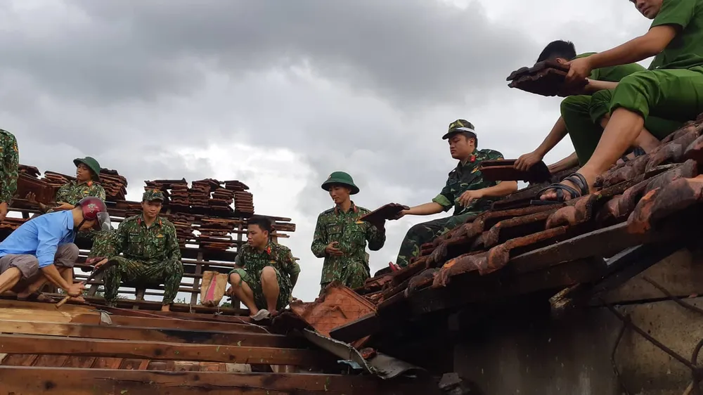 Lực lượng chức năng giúp người dân lợp lại mái nhà sau lốc xoáy