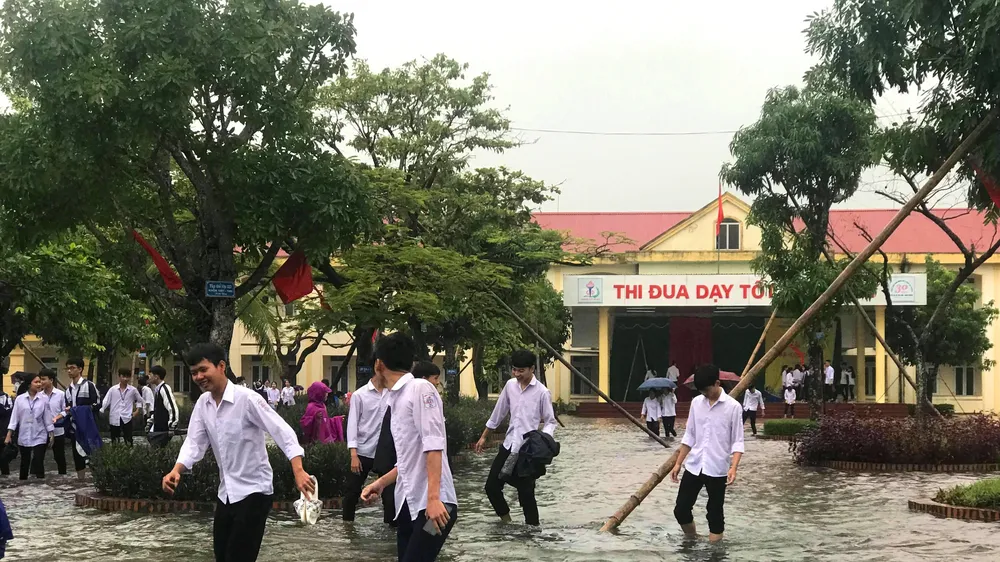 Nhiều em học sinh lội nước đến trường dự lễ khai giảng