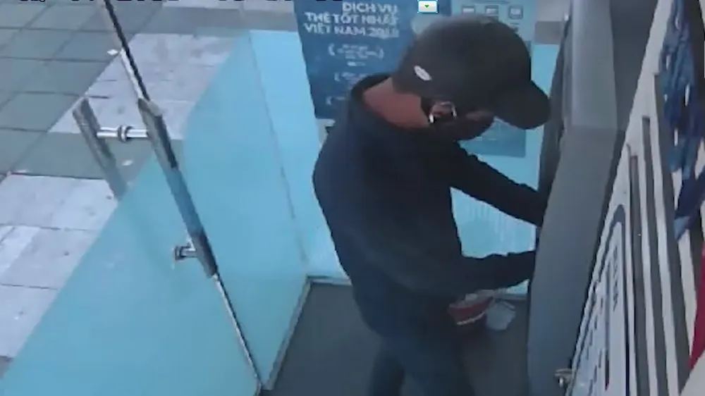 Nghi phạm thực hiện lắp đặt thiết bị trộm cắp thông tin tại cây ATM. Ảnh cắt lại từ clip