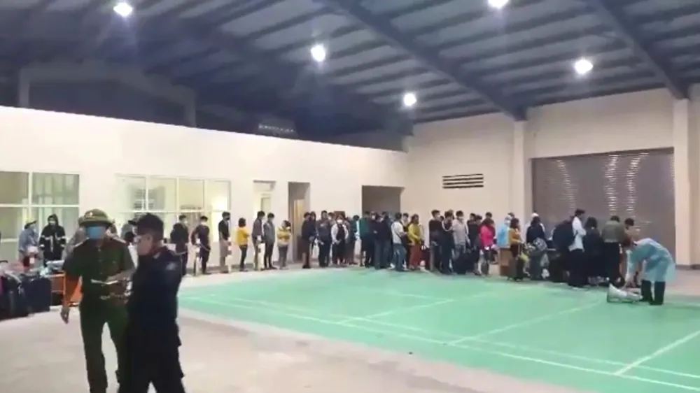 Người dân xếp hàng để được kiểm tra trước khi vào địa điểm cách ly tập trung