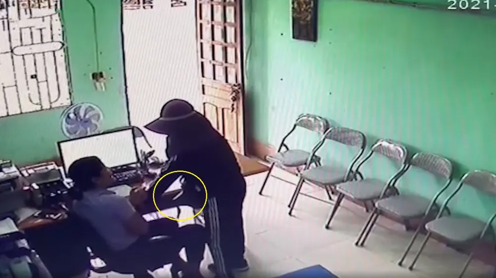 Nghi phạm đe dọa, khống chế nữ nhân viên Qũy tín dụng tại phòng làm việc. Ảnh cắt từ camera của Qũy tín dụng