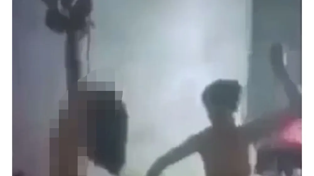 Hình ảnh cháu bé không mặc áo quần, hai tay bị trói treo lên trần nhà. Ảnh cắt lại từ video clip
