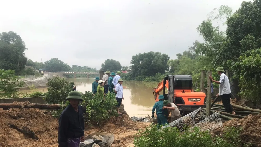 Lực lượng chức năng và người dân gia cố sạt lở bờ sông Ngàn Mọ