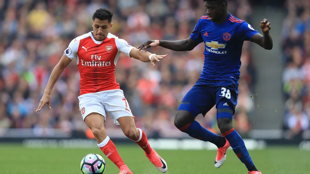  Alexis Sanchez (trái, Arsenal) tranh bóng với Axel Tuanzebe (Man.United).