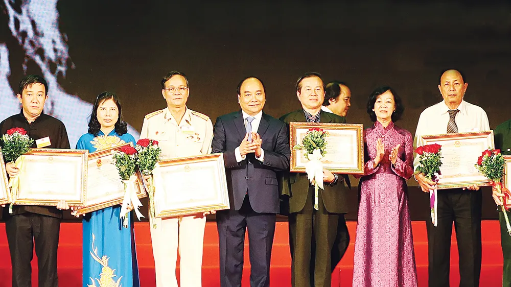 Thủ tướng Nguyễn Xuân Phúc trao bằng khen của Thủ tướng Chính phủ tặng các đại biểu dự Hội nghị biểu dương người có công với cách mạng tiêu biểu toàn quốc