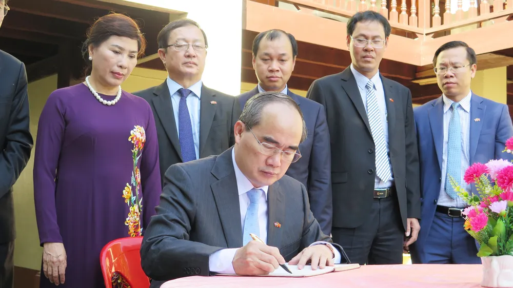 Bí thư Thành ủy TPHCM Nguyễn Thiện Nhân ghi vào sổ lưu niệm tại nhà lưu niệm Chủ tịch Cayson Phomvihan. Ảnh: KIỀU PHONG