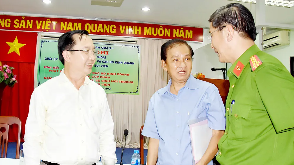 Chủ tịch UBND quận 1 Trần Thế Thuận và đại diện Công an quận 1 tri ân những đóng góp của ông Trần Văn Thanh (giữa) cho cuộc sống bình yên của người dân phường Phạm Ngũ Lão