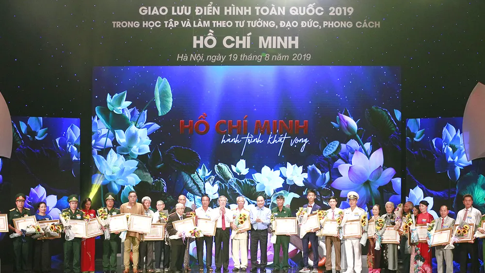 Thủ tướng Nguyễn Xuân Phúc trao bằng khen của Thủ tướng Chính phủ cho những cá nhân và điển hình tiên tiến trong học tập và làm theo tấm gương đạo đức Hồ Chí Minh trong chương trình giao lưu điển hình toàn quốc 2019. Ảnh: TRẦN BÌNH