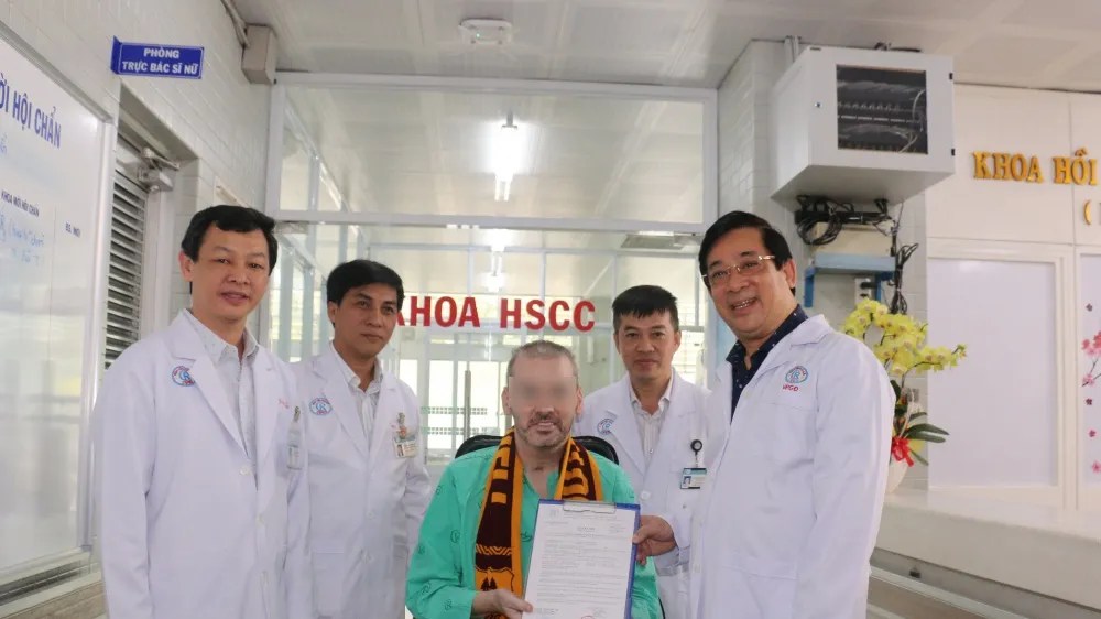 Bệnh nhân 91 - nhận giấy chứng nhận xuất viện từ PGS.TS Lương Ngọc Khuê- Cục trưởng Cục Quản lý Khám chữa bệnh, Phó Trưởng Tiểu ban Điều trị. Ảnh: BVCR