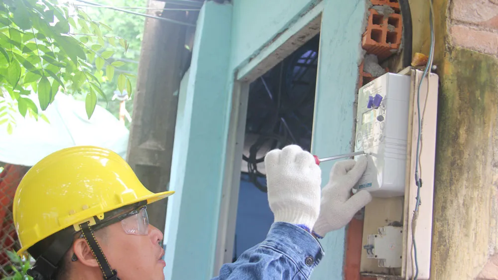 Nhân viên EVNHCMC gắn điện kế cho khách hàng