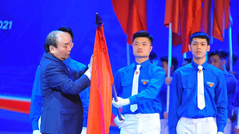 Thủ tướng Nguyễn Xuân Phúc gắn Huân chương Hồ Chí Minh lên cờ truyền thống của Trung ương Đoàn TNCS Hồ Chí Minh. Ảnh: TTXVN