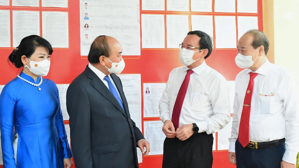 Chủ tịch nước Nguyễn Xuân Phúc trao đổi cùng Bí thư Thành ủy TPHCM Nguyễn Văn Nên sau khi bỏ phiếu. Ảnh: VIỆT DŨNG