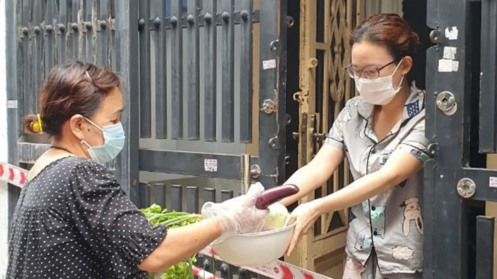 Người dân trong khu phong tỏa tại quận Tân Phú (TPHCM) được chăm lo thực phẩm, an tâm ở nhà phòng chống dịch. Ảnh: THÁI PHƯƠNG