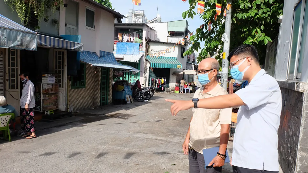 Bí thư Chi bộ khu phố 3, phường 9 (quận 4) Tiêu Quang và cán bộ phụ trách đô thị phường 9 khảo sát tình hình trật tự lòng lề đường