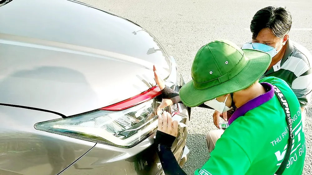 Nhiều tài xế phải dừng xe trên đường cao tốc để dán thẻ thu phí tự động. Ảnh: HOÀNG BẮC