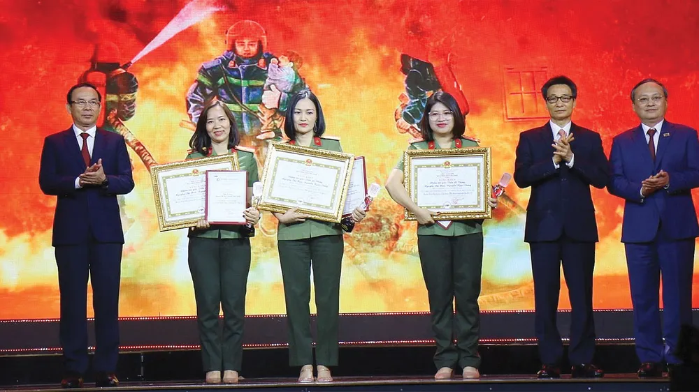 Bí thư Thành ủy TPHCM Nguyễn Văn Nên, Phó Thủ tướng Chính phủ Vũ Đức Đam và Tổng Giám đốc Đài Tiếng nói Việt Nam Đỗ Tiến Sỹ trao giải đặc biệt cho các tác giả tác phẩm Giữa lằn ranh sinh tử. Ảnh: DŨNG PHƯƠNG