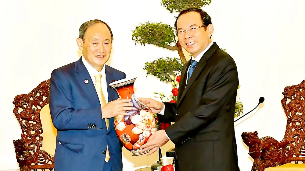 Bí thư Thành ủy TPHCM Nguyễn Văn Nên tặng quà lưu niệm Nguyên Thủ tướng Nhật Bản Suga Yoshihide. Ảnh: VIỆT DŨNG
