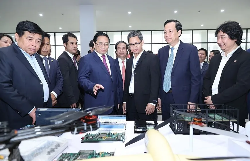 Thủ tướng Phạm Minh Chính tham quan trưng bày các sản phẩm nghiên cứu, chế tạo của Đại học Quốc gia Hà Nội cơ sở Hòa Lạc. Ảnh: TTXVN 