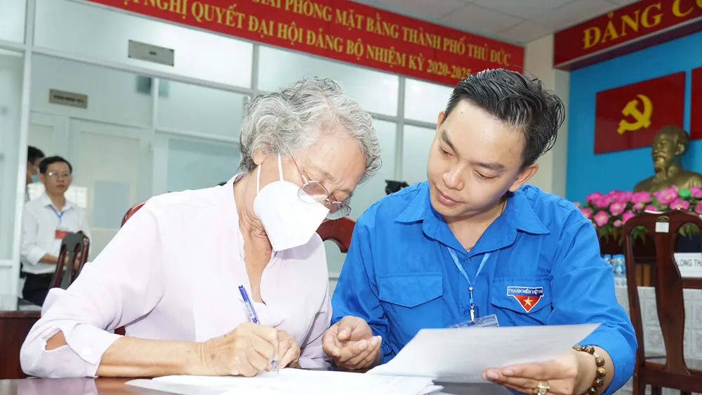 Cán bộ địa chính TP Thủ Đức (TPHCM) hướng dẫn người dân hoàn tất hồ sơ nhận tiền bồi thường của dự án đường Vành đai 3 TPHCM. Ảnh: HOÀNG HÙNG