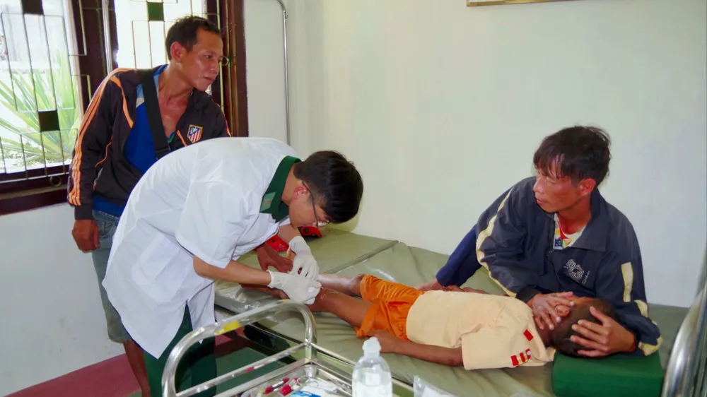 Bác sĩ quân y BĐBP tỉnh Thừa Thiên Huế tại trạm xá quân dân y xã A Đớt sơ cứu cho cháu bé bản Ka Lô, huyện Kà Lừm, tỉnh Sekong bị tai nạn
