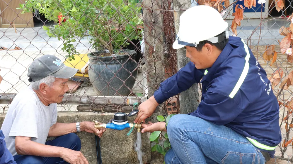 Ông Nguyễn Văn Tới (trái), ngụ tổ 4, ấp An Hòa, xã Tam Thôn Hiệp (huyện Cần Giờ) trong niềm vui được gắn đồng hồ nước thông minh