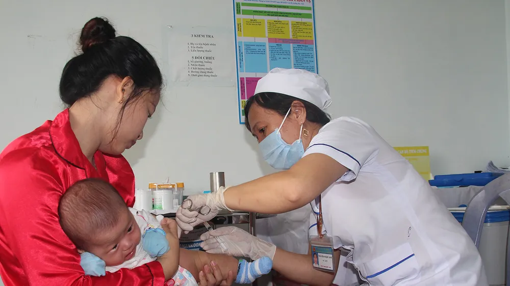 Nhân viên y tế thuộc Trạm Y tế xã Lâm Hải (huyện Năm Căn, tỉnh Cà Mau) tiêm chủng cho trẻ em. Ảnh: TẤN THÁI