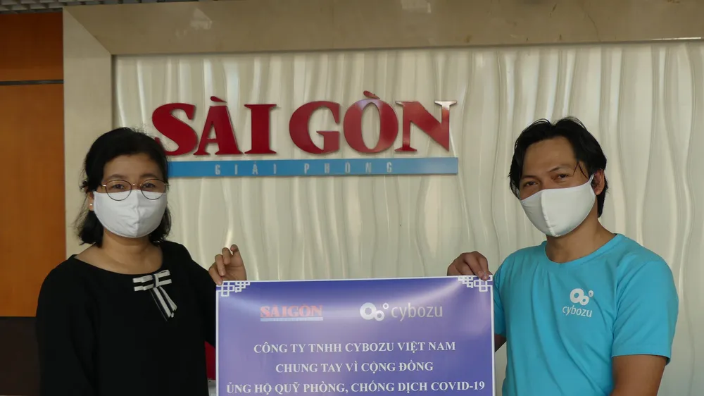 Bà Lý Việt Trung, Phó Tổng Biên tập Báo Sài Gòn Giải Phóng, tiếp nhận bảng trao tượng trưng đóng góp của Công ty TNHH Cybozu Việt Nam ủng hộ công tác phòng chống dịch Covid-19