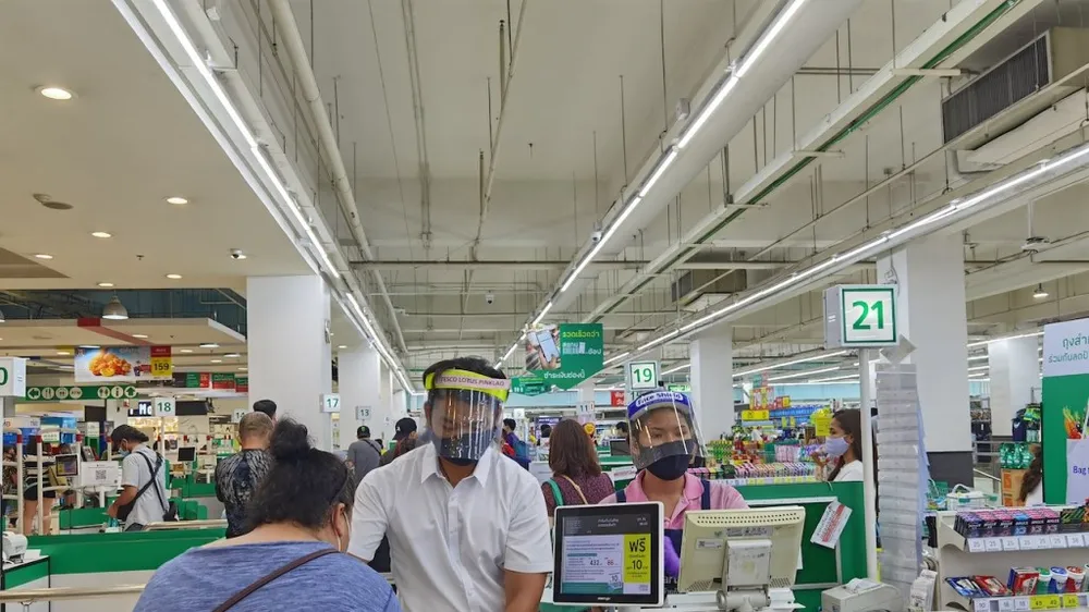 Nhân viên siêu thị tại Bangkok đeo khẩu trang và che mặt để phòng, ngừa Covid-19