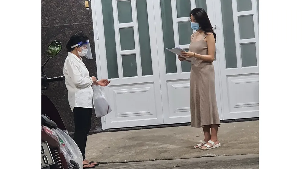  Bà Lê Thị Ngọc Bối (trái), Tổ trưởng Tổ 46 (khu phố 3, phường 19, quận Bình Thạnh) đến nhà phát phiếu đăng ký tiêm vaccine cho người dân