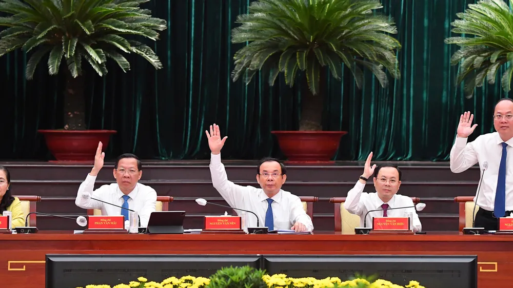 Các đồng chí lãnh đạo TPHCM biểu quyết thông qua nghị quyết hội nghị. Ảnh: VIỆT DŨNG