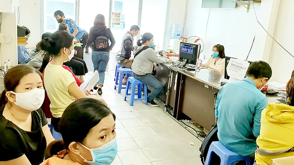 Người dân đang thực hiện các thủ tục bảo hiểm tại Bảo hiểm xã hội quận Gò Vấp. Ảnh: ĐOÀN HIỆP