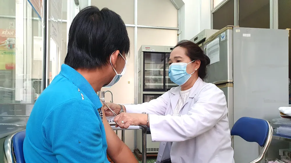 Nhân viên Trung tâm Y tế Quận 8 (TPHCM) tiêm vaccine Covid-19 cho người dân. Ảnh: THÀNH SƠN