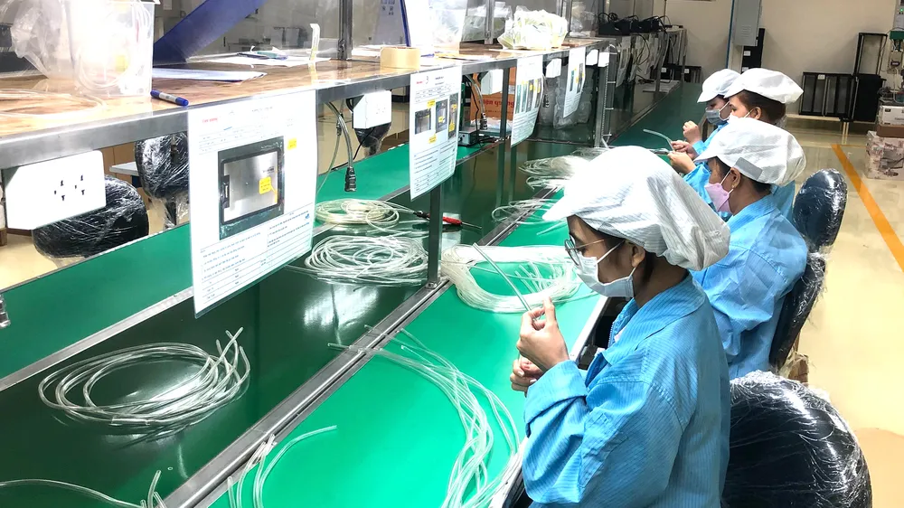 Công nhân Công ty cổ phần Bóng đèn Điện Quang lắp ráp thiết bị