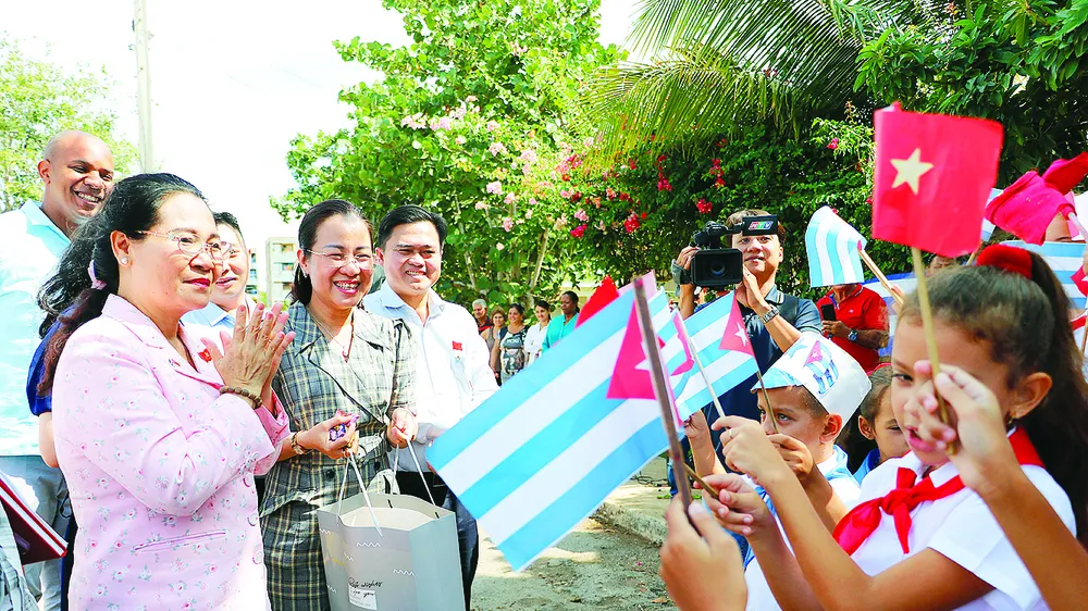Các em học sinh làng Bến Tre đón đoàn đại biểu TPHCM đến thăm. Ảnh: NGÔ BÌNH 