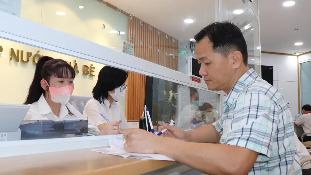 Nhân viên ngành cấp nước TPHCM hướng dẫn người dân đăng ký định mức nước qua ứng dụng VNeID